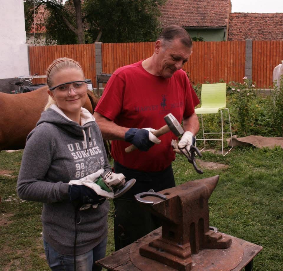 Marieke en haar vader bij het aambeeld met een hoefijzer