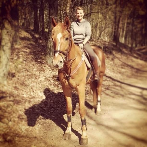 Marieke te paard op een bospad