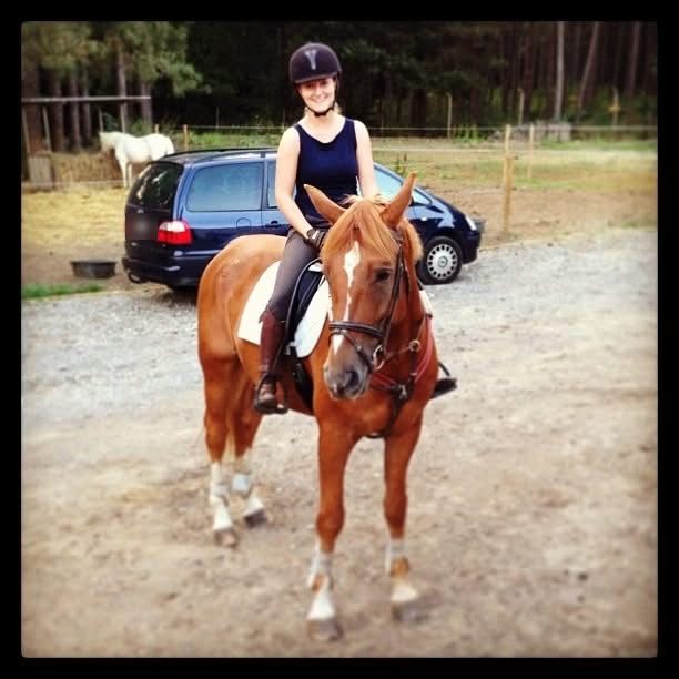 Marieke als tiener te paard op het erf