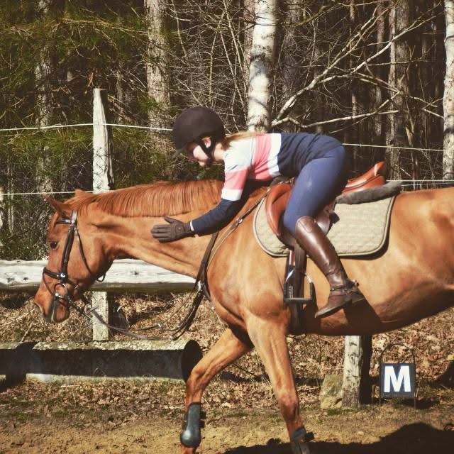 Marieke knuffelt haar paard vanuit het zadel