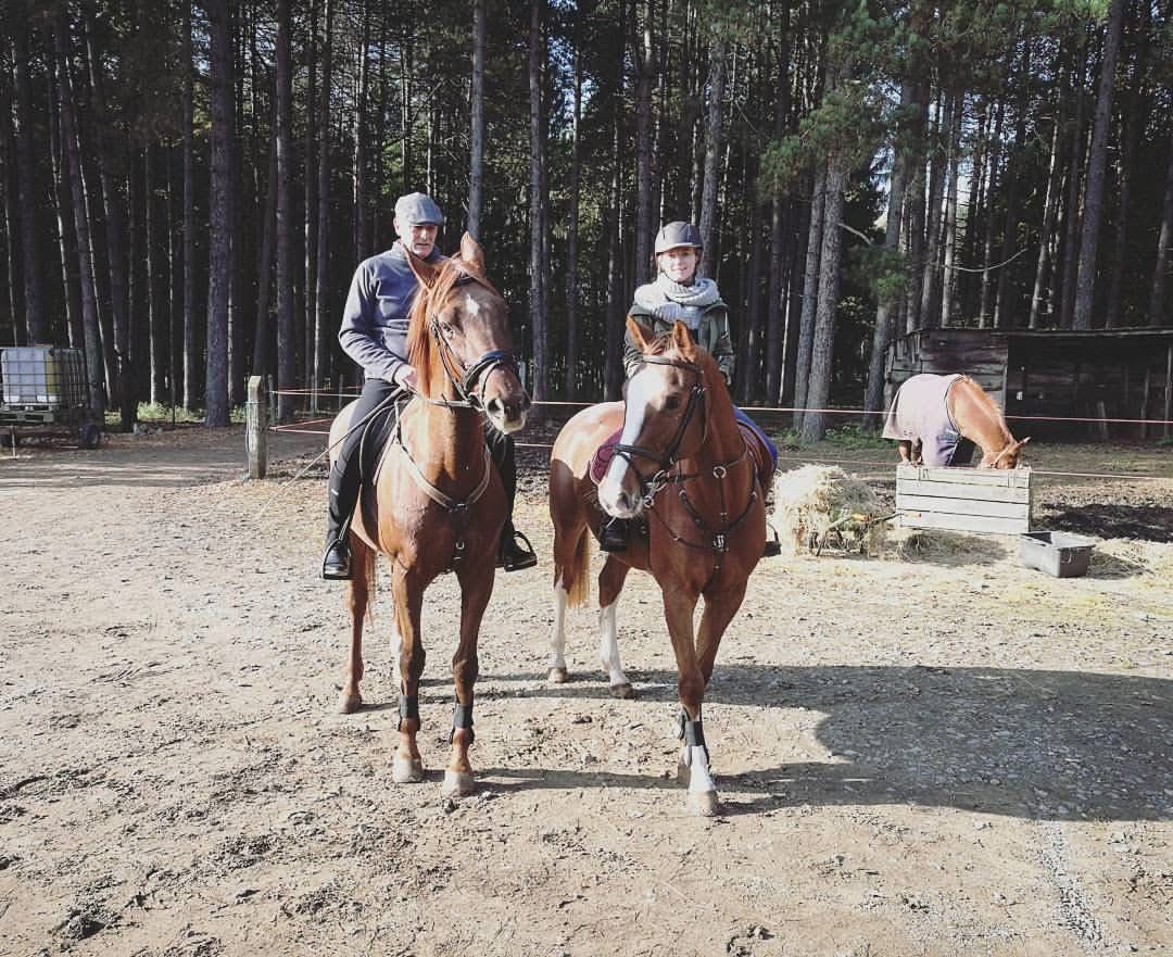 Marieke en haar vader Jan samen te paard aan de rand van het dennenbos
